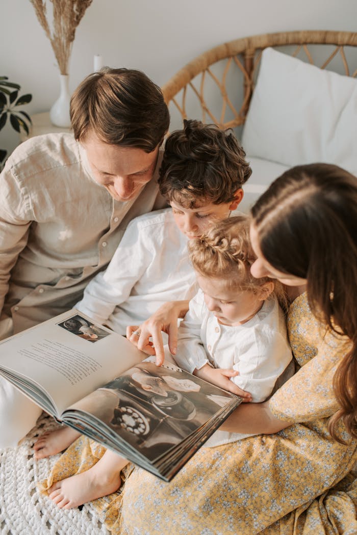 A family enjoys quality time reading a book together, embracing the joy of parenthood.